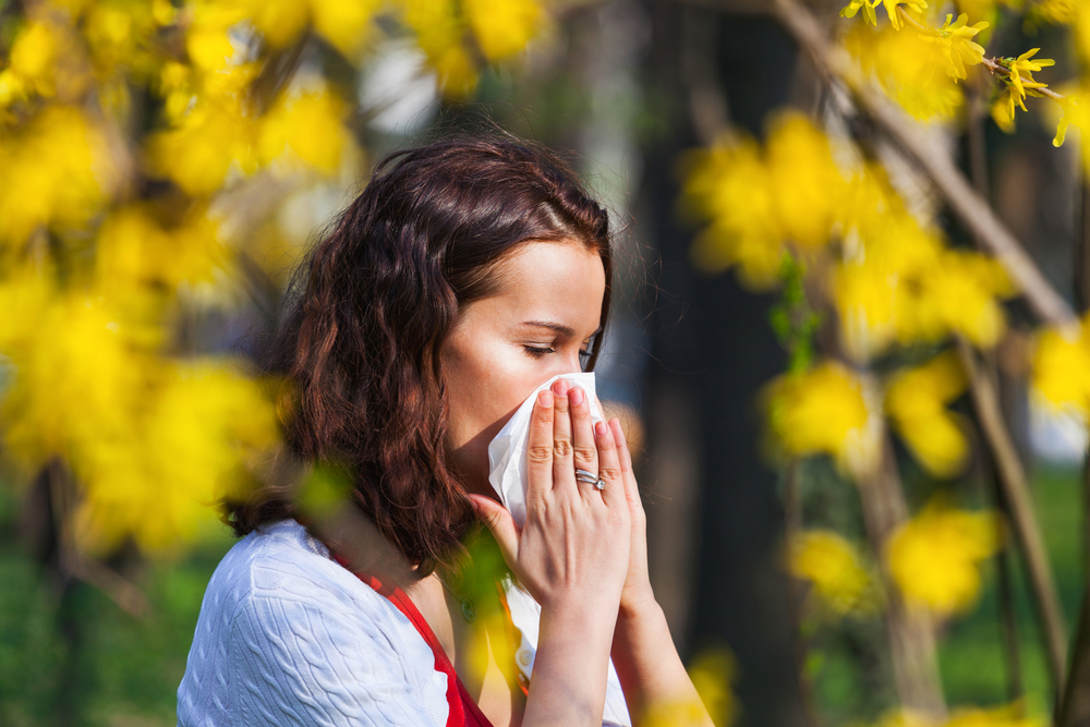 Woman outdoors blowing her nose