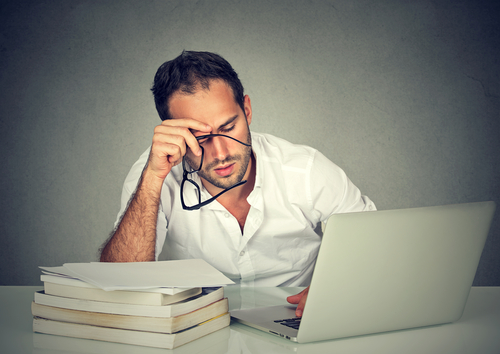 Tired man looking at computer